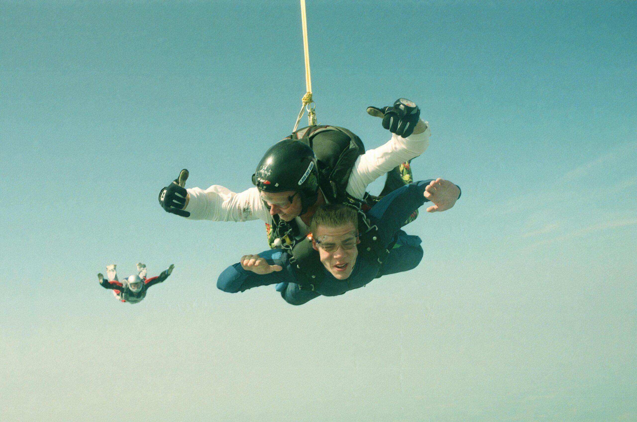 Experience the thrill of tandem skydiving with a clear blue sky backdrop.